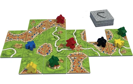Carcassonne-bordspeltegels die een middeleeuws landschap vormen met spelerspionnen die over de zich uitbreidende kaart worden geplaatst.