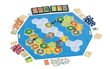 Complete Catan-bordspelopstelling met zeshoekige tegels, kaarten en grondstoffiches die op een tafel zijn uitgelegd voor het spel.